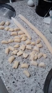 Rolling out potato gnocchi dough.
